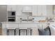 Elegant kitchen featuring white cabinets, an island with seating, and stainless-steel appliances at 13758 Tybee Beach Ln, Orlando, FL 32827