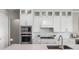 Modern kitchen with white cabinets, stainless steel appliances, and a large island at 13758 Tybee Beach Ln, Orlando, FL 32827