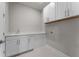 Bright laundry room featuring white cabinetry, countertop with sink and modern finishes at 13758 Tybee Beach Ln, Orlando, FL 32827
