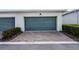 Attached garage with brick paver driveway and manicured landscaping on a sunny day at 14538 Orchid Island Dr, Orlando, FL 32827