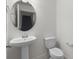 Simple half bath with pedestal sink, round mirror and toilet at 14538 Orchid Island Dr, Orlando, FL 32827