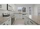 Bright kitchen featuring a granite countertops, white cabinetry, and stainless steel appliances at 14538 Orchid Island Dr, Orlando, FL 32827