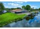 Aerial view of the home, lush lawn, pool, screened-in patio, and boat dock at 1620 Texas Ct, Tavares, FL 32778