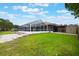 Lush backyard with a screened-in pool and boat storage, ideal for outdoor enjoyment at 1620 Texas Ct, Tavares, FL 32778