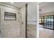 Modern bathroom with updated tile shower with a built-in shelf and glass doors at 1620 Texas Ct, Tavares, FL 32778