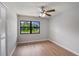 Bright bedroom with wood floors and a view of the manicured lawn, and a ceiling fan at 1620 Texas Ct, Tavares, FL 32778