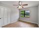 Bright bedroom with wood floors, closet, window overlooking a manicured lawn, and a ceiling fan at 1620 Texas Ct, Tavares, FL 32778