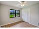 Bright bedroom with wood floors, closet, window overlooking a manicured lawn, and a ceiling fan at 1620 Texas Ct, Tavares, FL 32778