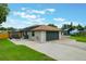 View of the house with a large driveway, two car garage, and boat trailer with a dock nearby at 1620 Texas Ct, Tavares, FL 32778