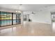 Open living room with tiled floors, ceiling fan and large windows overlooking the pool at 1620 Texas Ct, Tavares, FL 32778