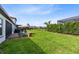 Lush backyard with brick patio, grill, and serene privacy hedging at 16696 Otterchase Ln, Winter Garden, FL 34787
