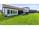 Expansive backyard featuring lush grass, brick patio, and privacy landscaping at 16696 Otterchase Ln, Winter Garden, FL 34787