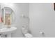 Well-lit powder room featuring a pedestal sink, toilet, and neutral decor at 16696 Otterchase Ln, Winter Garden, FL 34787