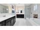 Large bathroom showcasing a soaking tub, glass shower, and dual sink vanity with stone countertops at 16696 Otterchase Ln, Winter Garden, FL 34787