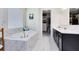 Bright bathroom showcasing a soaking tub, walk-in closet, and a double sink vanity at 16696 Otterchase Ln, Winter Garden, FL 34787