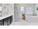 Modern bathroom with a soaking tub, glass shower, and dual sink vanity with stone countertops at 16696 Otterchase Ln, Winter Garden, FL 34787