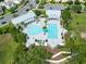 Aerial view of community pool, showcasing the resort-style amenities with palm trees and ample seating at 16696 Otterchase Ln, Winter Garden, FL 34787