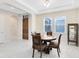 A dining room with a wooden table and chairs sits on white tile, illuminated by natural light at 16696 Otterchase Ln, Winter Garden, FL 34787