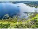 Scenic aerial view of a beautiful lake with surrounding greenery and a charming pier at 16696 Otterchase Ln, Winter Garden, FL 34787