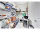 Organized pantry with metal shelving, work desk, and tiled floors for storage at 16696 Otterchase Ln, Winter Garden, FL 34787