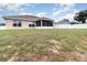 Backyard view of the home with a screened-in porch, expansive lawn and a fenced yard at 186 Nw 44Th St, Ocala, FL 34475