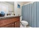 Well-lit bathroom featuring a single sink vanity and a toilet with a blue patterned shower curtain at 186 Nw 44Th St, Ocala, FL 34475