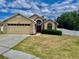 Charming one-story home featuring a two-car garage, brick accents, and a well-manicured lawn at 1980 Aquarius Ct, Oviedo, FL 32766