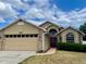 Charming one-story home featuring a two-car garage, brick accents, and a well-manicured lawn at 1980 Aquarius Ct, Oviedo, FL 32766
