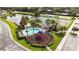 Overhead view of community amenities including a pool, playground, tennis courts, and a serene pond at 2204 San Vittorino Cir # 102, Kissimmee, FL 34741