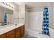 Well-lit bathroom features a vanity with cabinet storage and a shower-tub combo with a geometric shower curtain at 2204 San Vittorino Cir # 102, Kissimmee, FL 34741