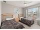 Bedroom with two wooden beds, ceiling fan, and a window overlooking the neighborhood at 2204 San Vittorino Cir # 102, Kissimmee, FL 34741