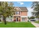 Charming two-story townhome featuring a landscaped front yard with healthy green grass and a welcoming entrance and walkway at 2204 San Vittorino Cir # 102, Kissimmee, FL 34741