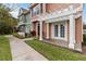 Exterior side view of a two-story townhome showing the yard, sidewalk, and covered porch at 2204 San Vittorino Cir # 102, Kissimmee, FL 34741