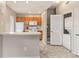 Bright kitchen featuring white appliances, wood cabinets, and a convenient laundry closet at 2204 San Vittorino Cir # 102, Kissimmee, FL 34741