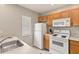 Efficient kitchen featuring white appliances, light wood cabinets, and a breakfast bar with plenty of natural light at 2204 San Vittorino Cir # 102, Kissimmee, FL 34741