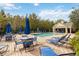 Community pool with lounge chairs, tables, umbrellas, and a clubhouse surrounded by trees offers a relaxing oasis at 2204 San Vittorino Cir # 102, Kissimmee, FL 34741