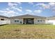 Backyard view of a home featuring a covered patio, a privacy fence, and a well-manicured lawn at 2249 Palmetum Loop, Apopka, FL 32712