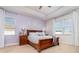 Bedroom features a tray ceiling and a wooden bed frame and matching end tables at 2249 Palmetum Loop, Apopka, FL 32712