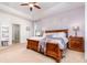 Bedroom featuring a tray ceiling and a wooden bed frame and matching end tables at 2249 Palmetum Loop, Apopka, FL 32712