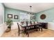 The dining room features a dark wood table with seating for six beneath a stylish three-light pendant at 2249 Palmetum Loop, Apopka, FL 32712