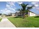 A sunny shot of a well-maintained home featuring a palm tree and a lush green lawn at 2249 Palmetum Loop, Apopka, FL 32712