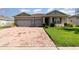 Charming single-story home with a brick driveway, well-manicured lawn, and a welcoming front entrance at 2249 Palmetum Loop, Apopka, FL 32712