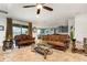 Bright living room featuring comfortable sofas, a ceiling fan, and a view into the dining area and kitchen at 2249 Palmetum Loop, Apopka, FL 32712