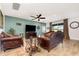 Cozy living room featuring comfortable leather sofas, stylish decor, and a ceiling fan at 2249 Palmetum Loop, Apopka, FL 32712