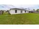 The backyard features a well-maintained lawn and a white house with black trim windows and a back door at 2486 Ainsworth Ave, Deltona, FL 32738