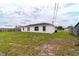 The backyard features a well-maintained lawn and a white house with black trim windows and a back door at 2486 Ainsworth Ave, Deltona, FL 32738