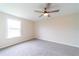 Neutral bedroom with a ceiling fan, large window and plush carpeting at 2486 Ainsworth Ave, Deltona, FL 32738