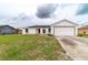 Charming single-story home with a well-maintained lawn and a bright red front door at 2486 Ainsworth Ave, Deltona, FL 32738