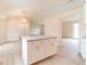 A kitchen island opens up to a well-lit room, featuring a stylish light fixture at 2486 Ainsworth Ave, Deltona, FL 32738