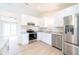 A well-lit kitchen with stainless steel appliances, white cabinets, and wood-look flooring at 2486 Ainsworth Ave, Deltona, FL 32738